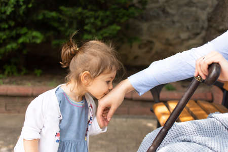 A little girl sits on a swing and looks at her mother.