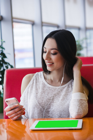 Beautiful girl listening music on the phone with headphonesの写真素材