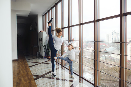 Mother learning daughter to make a high leg strech
