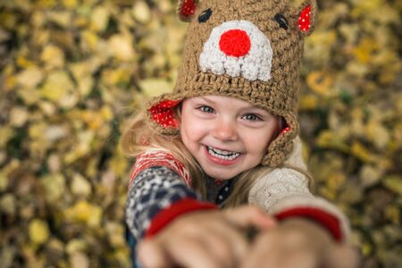 girl laughing at the camera on a background of yellow leaves