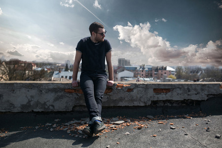 The man in the authentic boots and jeans selvedge on the roof of the building in the old townの写真素材