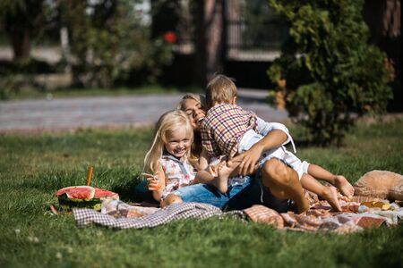 Mother with kids have fun on the grassの写真素材