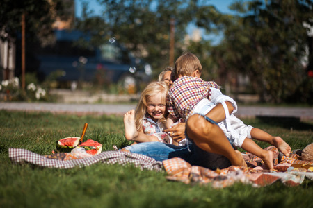 Mother with kids have fun on the grassの写真素材