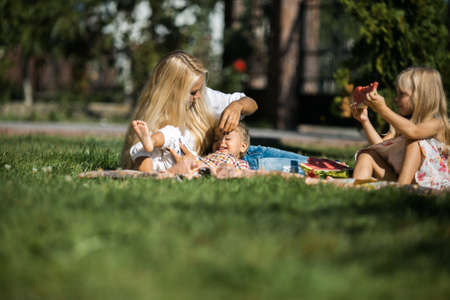 Mother with kids have fun on the grassの写真素材