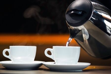 two cups of tea and teapot with hot waterの写真素材