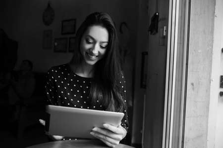 Beautiful girl working on a tablet and smilingの写真素材