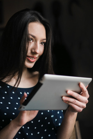 Beautiful girl working on a tablet and smilingの写真素材