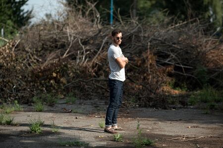 The man in the authentic boots and selvedge jeans  on a the background of branchesの写真素材