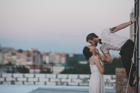 beautiful couple together on the roof of a tall buildingの写真素材