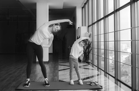 Two girls of different ages makeing yogaの写真素材