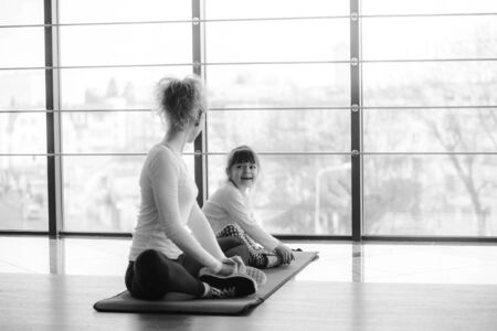 Two girls of different ages makeing yogaの写真素材