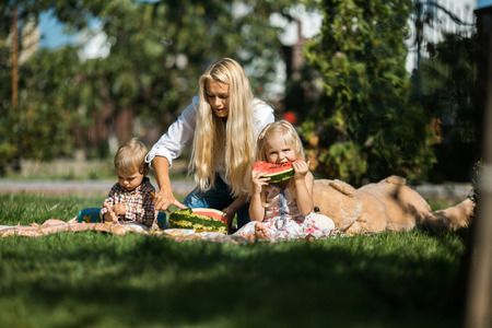 Mother with kids have fun on the grassの写真素材