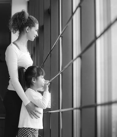 Two girls of different ages stare in a window in the gymの写真素材