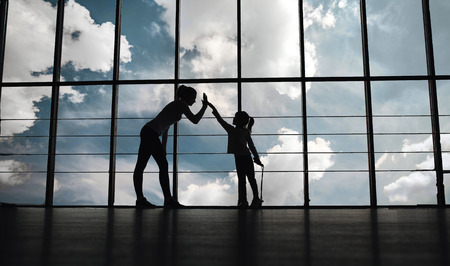 Silhouette of mother and daughter in the gym.high five.の写真素材