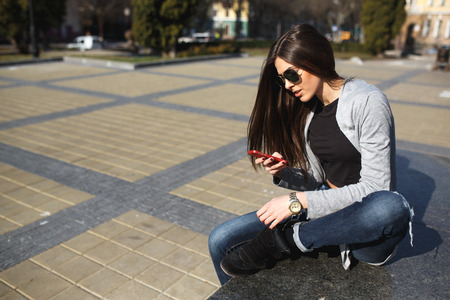 young girl posing on a background of the cityの写真素材