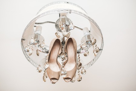 beautiful wedding shoes hanging from the chandelierの写真素材