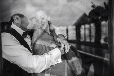 Wedding couple together close to each other at the windowの写真素材