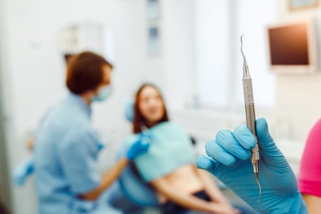 dentist and assistant in his office taking patientの写真素材