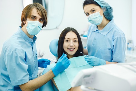 dentist and assistant in his office taking patientの写真素材