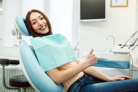 Beautiful patient sits in a chair at the dentistの写真素材