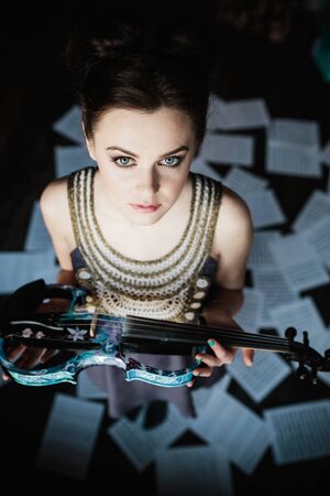 girl posing in a room and holding a violinの写真素材