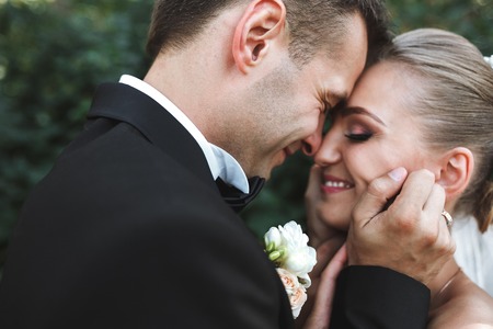 the bride and groom posing together at camera on the background of natureの写真素材