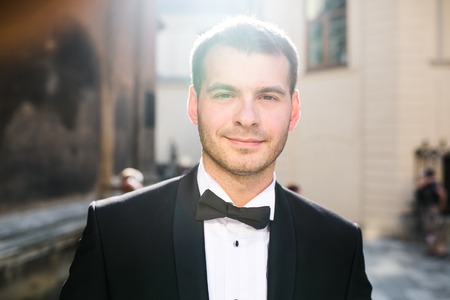 handsome groom posing for the camera in the cityの写真素材