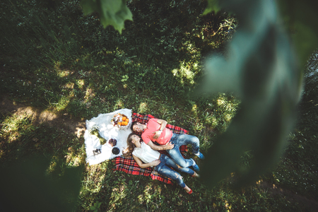 Photo beautiful couple under a tree on a background of grassの写真素材