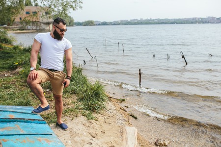 American Bearded Man looks on the river bank in a blue jacketの写真素材