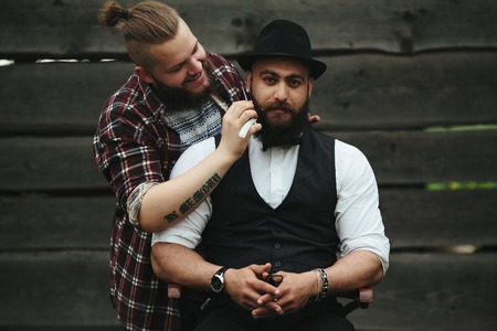 barber shaves a bearded man in vintage atmosphereの写真素材