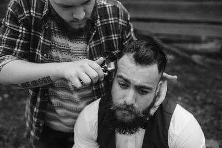 barber shaves a bearded man in vintage atmosphereの写真素材