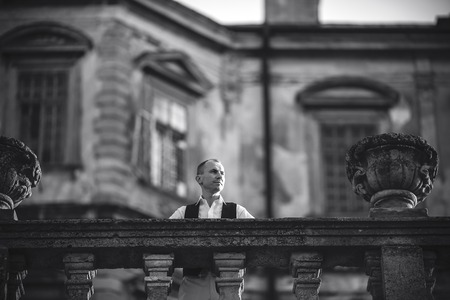 Handsome man posing on a background of the old castleの写真素材