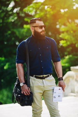 bearded man with a map in hand looking awayの写真素材