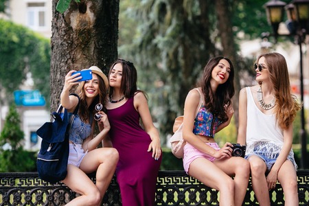 four beautiful young girls make selfie in the parkの写真素材