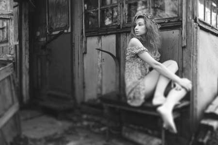 beautiful girl walks in the lush garden dressed in a wreathの写真素材