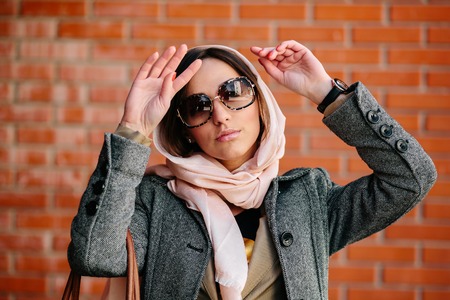 young and beautiful girl posing on a background of red brick wall, close angleの写真素材