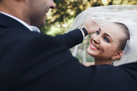 the bride and groom posing together at camera on the background of natureの写真素材