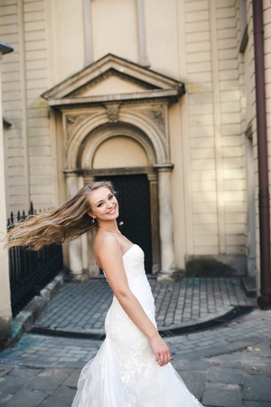 Beautiful bride posing against the backdrop of the ancient churchの写真素材