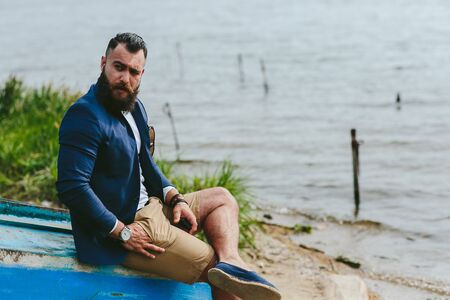 American Bearded Man looks on the river bank in a blue jacketの写真素材