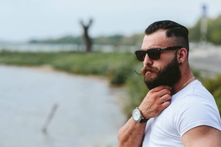 American Bearded Man looks on the river bank in a blue jacketの写真素材