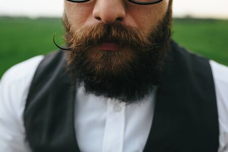 Man with a beard and glasses in the green fieldの写真素材