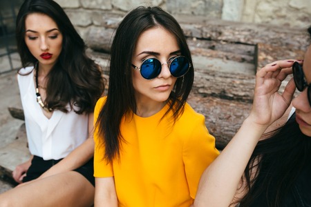 Three young beautiful girls posing against the backdrop of an abandoned buildingの写真素材