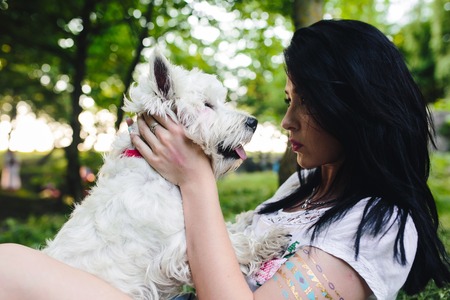 Young girl playing in the park with his dogの写真素材