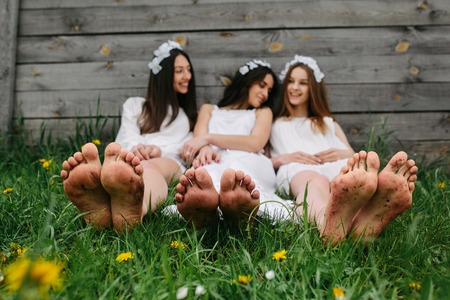 three beautiful girls on the background of a wooden houseの写真素材