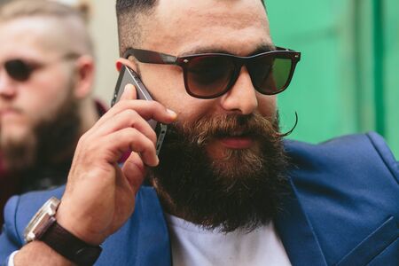 two businessmen talking on the phone in the cityの写真素材