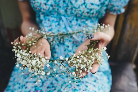 beautiful girl walks in the lush garden dressed in a wreathの写真素材