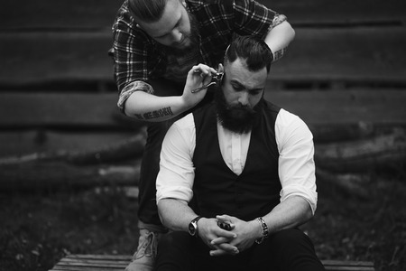 barber shaves a bearded man in vintage atmosphereの写真素材
