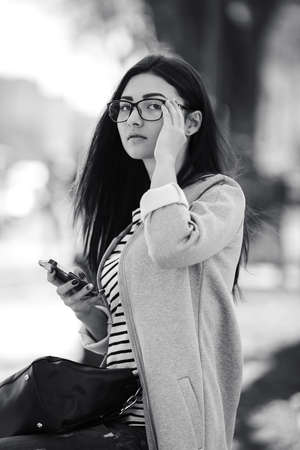 Charming beautiful fashion model in the glasses, sits