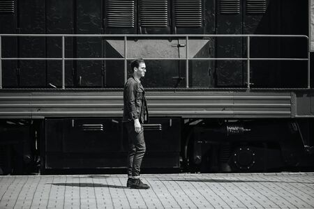 A man dressed in jeans on the background of the train and the stationの写真素材