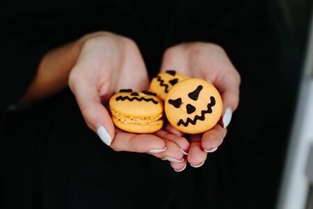 woman holding a biscuit for Halloween on black backgroundの写真素材